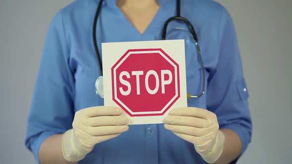 Stop Sign in Female Physician Hands, Doctor Warning About Diseases, Health Care alt