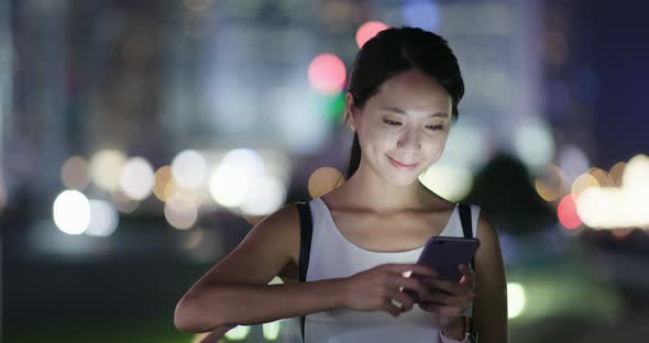 Woman use of smart phone in city at night alt