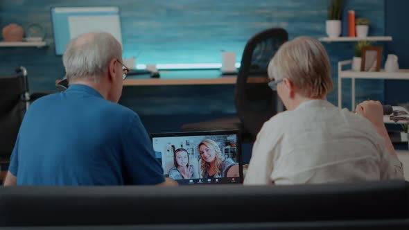 Elder Couple Using Online Teleconference to Chat with Relatives alt