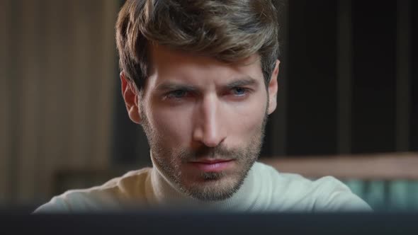 Portrait of a Young Designer Working on a Laptop Focused Man Working Overtime the Thinking Process