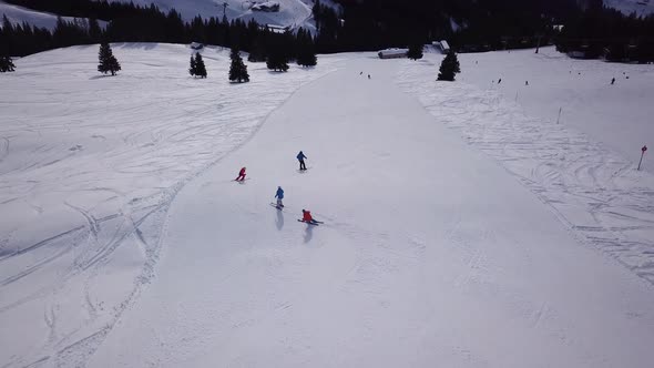 Aerial view of ski resort with people snowboarding down the hill. Stock footage. Flying over the ski alt