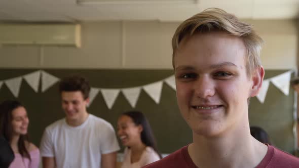 Portrait of teenage boy in school classroom alt