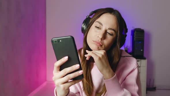 Worried Young Woman Holding Phone Feeling Jealousy Anxiety Waiting for Mobile Call Sit Alone at Home alt