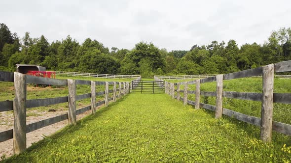 Two pastures with wooden fences on a countryside farm. alt