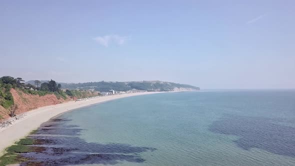 Aerial view of the white sandy beautiful beach in Seaton England. The clear blue water and the warm alt