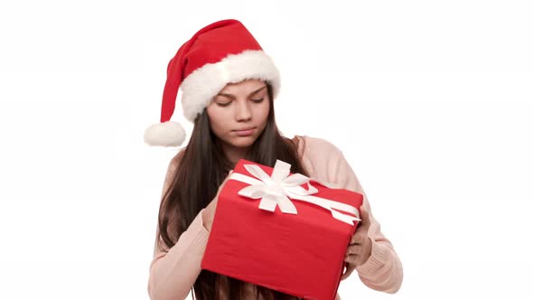 Portrait of Beautiful Woman in Santa Claus Red Hat Being Puzzled Expressing Curiosity While Trying alt
