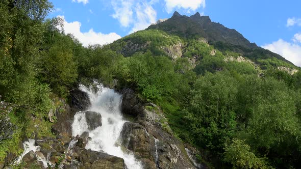 Waterfall in mountains in national park of Dombay