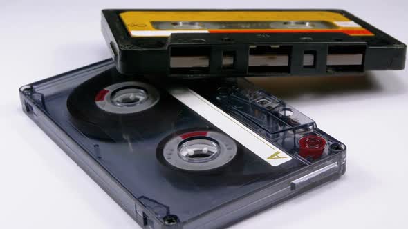 Two Vintage Audio Cassette Rotates on White Background alt