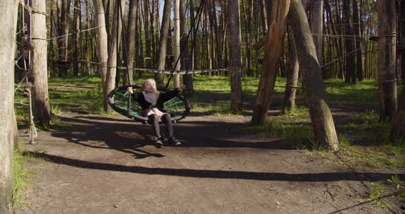 Little Girl Swinging On A Swing In The Recreation Park alt