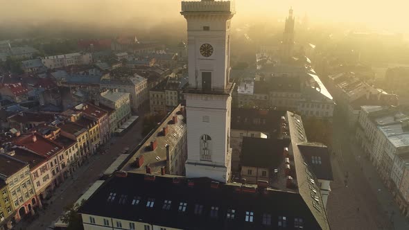 Flying Over Morning Foggy Lviv City in Ukraine. Scenic Summer Aerial View of the Market Square alt