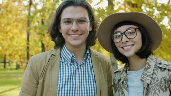 Happy Youth Girl and Guy Smiling Looking at Camera in Urban Park Feeling Joyful alt