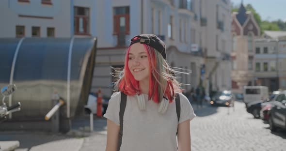 Fashionable Beautiful Teenager Girl with Trendy Colorful Hair Walking Along Street of City alt