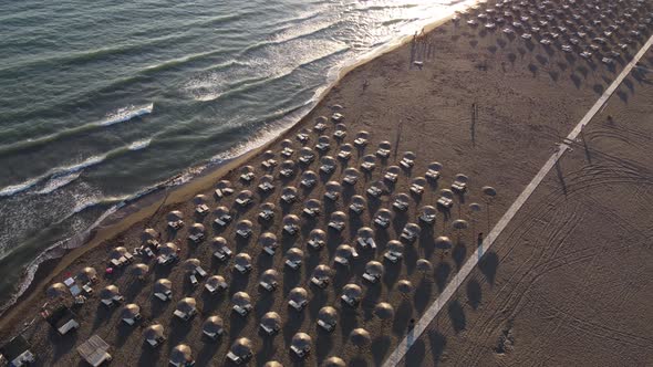 Aerial view Top view of Beautiful sea sandy beach with umbrellas and waves crashing against sand 