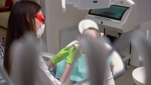 Little Cute Girl at Dentist Clinic Gets Dental Treatment to Fill a Cavity in a Tooth alt