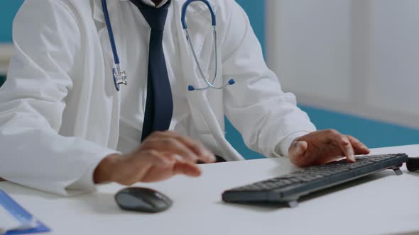 Portrait of African American Therapist Doctor Sitting at Desk in Hospital Office alt