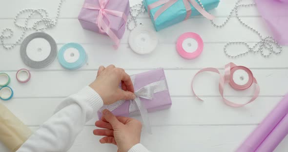 Hands packed Christmas gifts into paper boxes. New Year holidays. Gift wrapping. alt