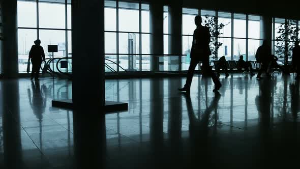 Silhouettes of Walking People on the Background of Glass