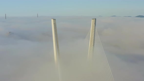 Tops of the Pylons of the Golden Bridge in the Dawn Fog in Vladivostok alt