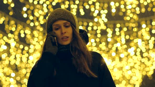 Portrait of a Happy Girl on a Evening Street Decorated with Christmas Lights alt