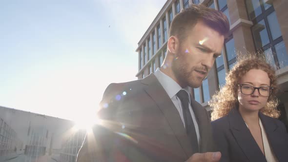 Two Business Colleagues Discussing Strategy Outside alt