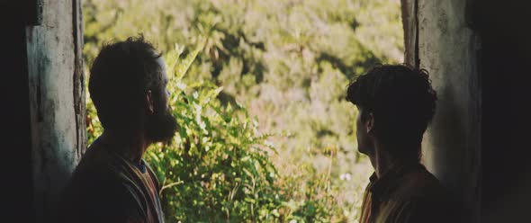 Two men standing in the doorframe, giving firm handshake alt