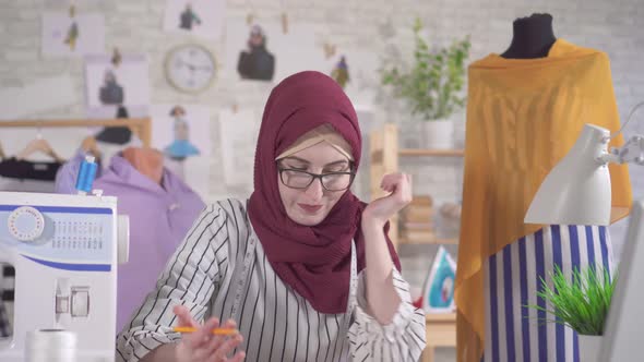 Young Muslim Woman Fashion Designer in National Headscarf Has Difficulty with Ideas No Inspiration alt