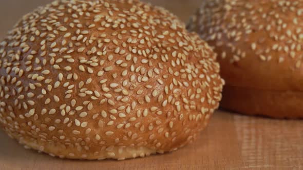 Fresh Hot Bun with Sesame Seeds on Wooden Cutting Board alt