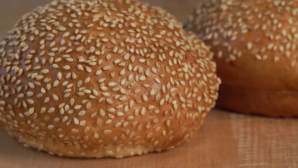Fresh Hot Bun with Sesame Seeds on Wooden Cutting Board