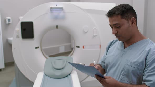 Male CT Tech Writing on Clipboard alt