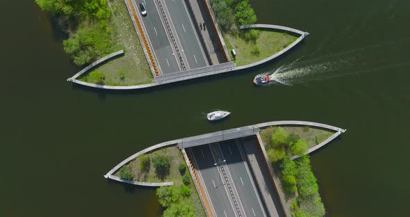 Small White sail boat passing above highway traffic at Aquaduct Veluwemeer, Harderwijk, The Netherla alt