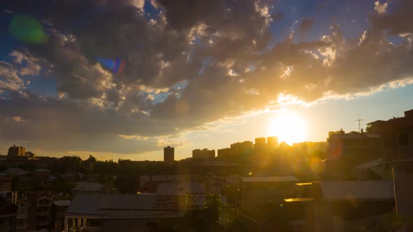 Timelapse of Dramatic Sunset Over Cityscape with Fluffy Clouds Rain and Golden Sun in Blue Sky