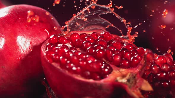 Slow Motion Shot of Pomegranate Juice Splashing Through Pomegranate alt