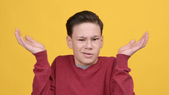 Teenager Boy Shrugging Shoulders Shaking Head In Disagreement Yellow Background alt
