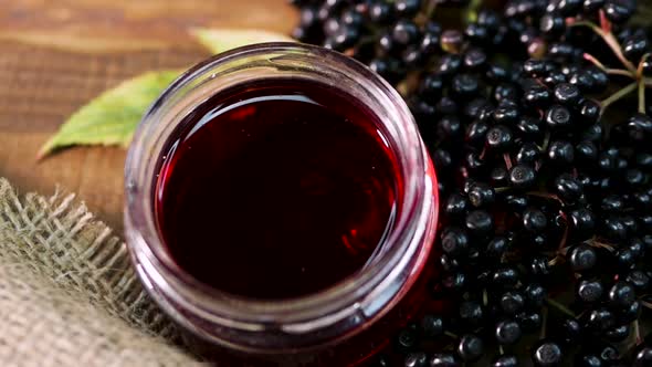 Natural Elderberry Juice In A Glass Jar. Black Elderberry On A Wooden Background. Herbal Medicine