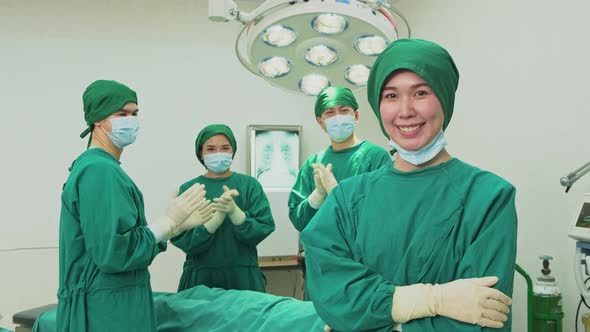 Asian professional surgeons and nurses suture feeling glad and clap hands after successful operation alt