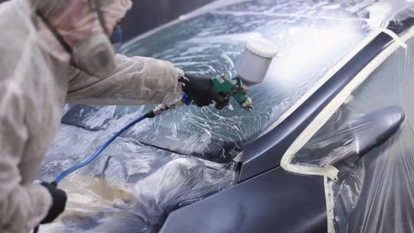 Master is Painting Part of Automobile in Car Service