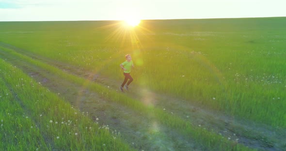 Sporty Child Runs Through a Green Wheat Field alt