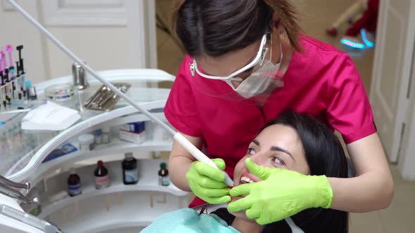 Woman at the Dental Hygienist Getting Professional Tooth Whitening and Ultrasound Cleaning alt