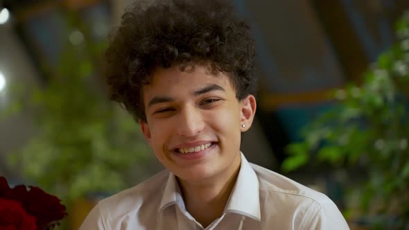 Closeup Portrait of a Young Handsome Guy Zoomer Mixed Race with an African Hairstyle Smiles and