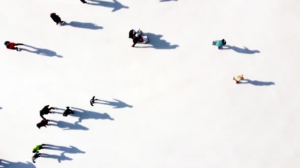 Many People are Skating on White Outdoor Ice Rink in City on Sunny Winter Day alt