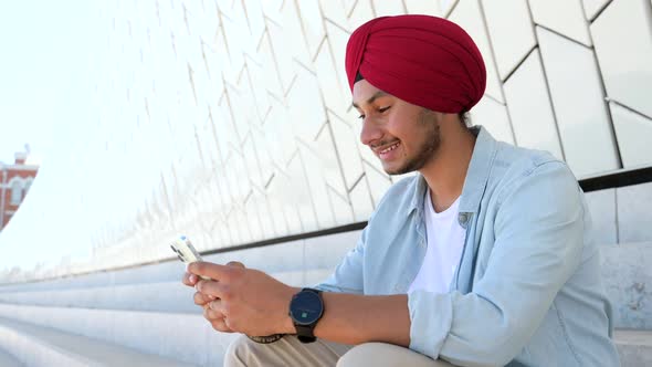 Indian Male Freelancer Student Entrepreneur Wearing Red National Turban Using Smartphone