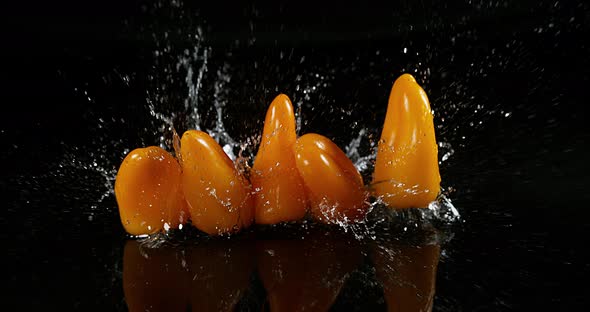 Yellow Sweet Peppers, capsicum annuum, Vegetable falling on Water against Black Background alt