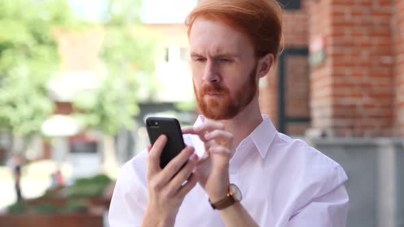 Man Using Smartphone While Standing Outside Building alt