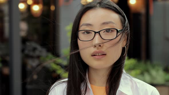 Portrait of Beautiful Trendy Asian Woman in Eyeglasses Smiling at Camera Looking alt