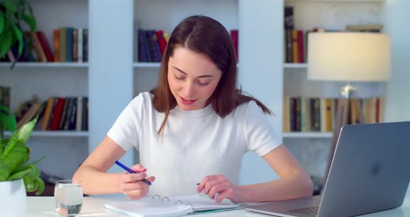 Happy Young Woman Takes Notes During Online Seminar Webinar Slow Motion