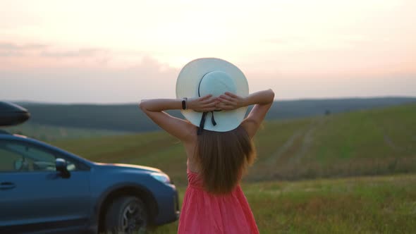 Young Woman Relaxing Alone on Green Field During Road Trip in Summer alt