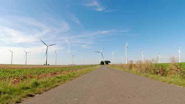 Drive overland in the direction of many electricity windmills as a symbol for clean wind energy