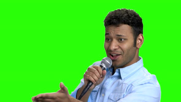 Energetic Entertainer Talking Into Microphone on Green Screen alt
