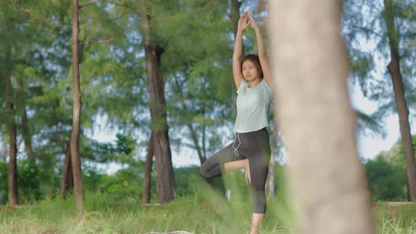 Asian cute girl She is doing yoga in the morning in the garden by the beach.