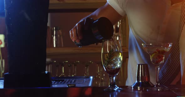 Bartender pouring cocktail drink into the glasses, 4K 4k alt